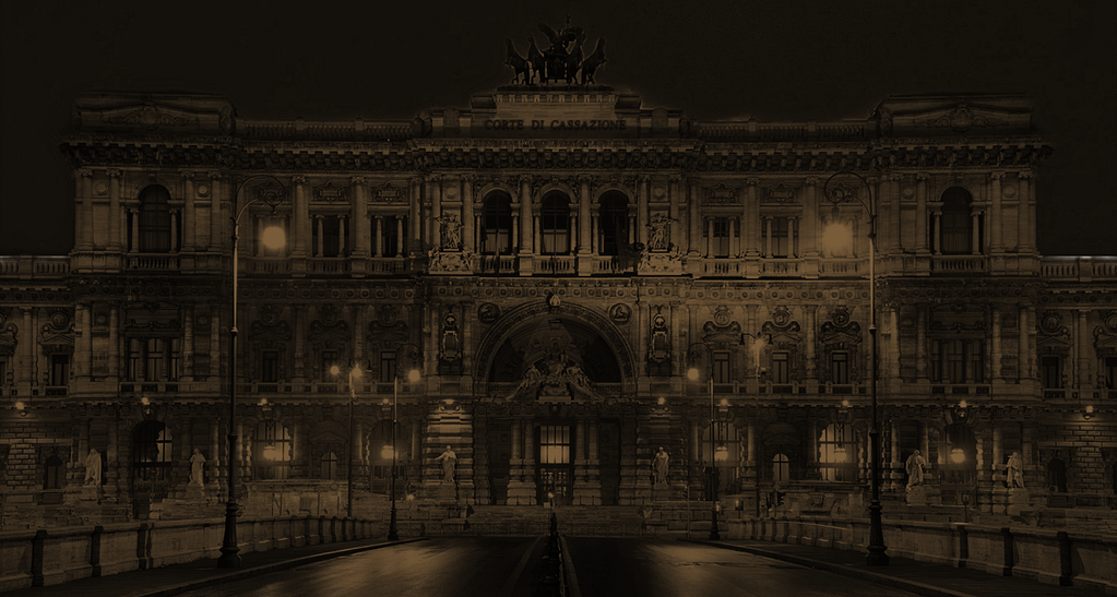 Immagine del Palazzo Storico con illuminazione notturna, evidenziando dettagli architettonici e atmosfera suggestiva.