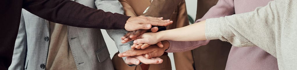 Un gruppo di mani unite in un gesto di collaborazione e unità, rappresentando teamwork e cooperazione.